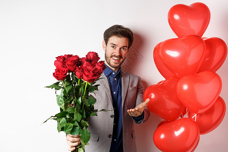 罗马人穿西装说情人节快乐 送红玫瑰给你 指着手 站在白色背景的心气球礼物上站立气球展示周年女朋友假期工作室情人促销广告惊喜背景图片