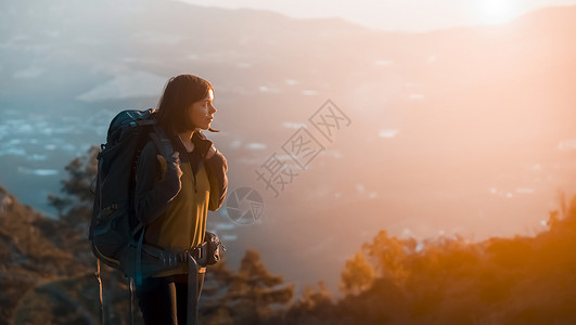 女孩在日落时正在山上攀爬看法高清图片素材