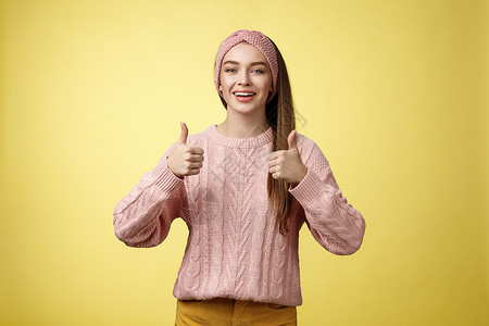 穿着针织毛衣的漂亮积极的年轻女孩同意建议 批准计划 竖起大拇指 推荐很棒的电影 微笑 欢呼 支持朋友的努力 鼓励女朋友客户购物大背景图片
