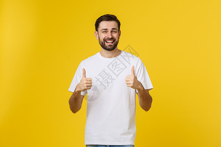 年轻快乐的男子与拇指举起标志 在空闲中孤立在黄色背景上手势白色胡须微笑衬衫成人成功幸福男性商业年轻的高清图片素材