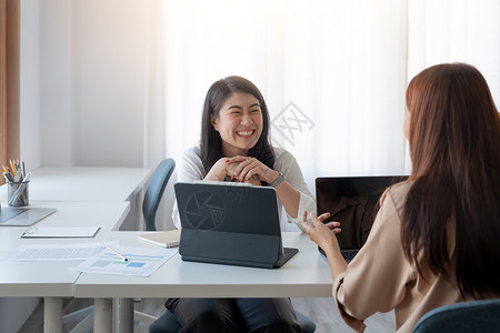 快乐的亚洲女商务人士向同事提出建议 初创企业团队在现代明亮的办公室开会会议室高清图片素材