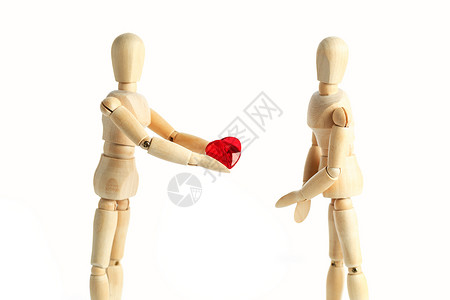 木制玩具两个木制的假人形象 给出了一颗红色的心 在白色背景中被隔离  爱情和情人节主题概念的图片女士奉献玩具数字模型讨论艺术身体男人会议背景