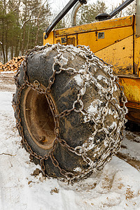 打滑特写黄伐木滑雪机上的冬季链车辆安全拖拉机建筑机器牵引力风险集材机木头林业背景