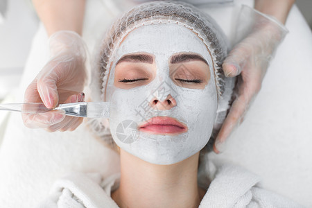 面部去角质面膜 水疗美容 护肤 美容师在 spa 沙龙接受面部护理的女人病人刷子皮肤温泉药品化妆品奶油身体面具按摩手高清图片素材