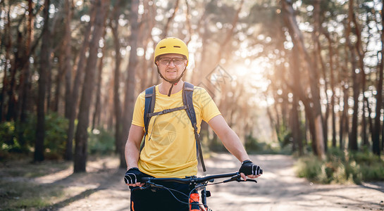 男人森林以自行车站在森林中的自行车站立的Cyclist背景