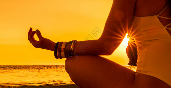班纳 年轻女子在沙滩上做瑜伽与日落 保持手指连接 阳光照耀着它们 健康生活方式 和谐的概念 笑声热带平衡女士身体女孩姿势海洋活力宗教高清图片素材