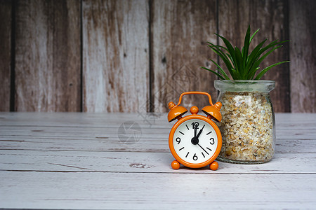 橙色闹钟在木制桌子上被隔绝 时钟设定在1点1个高清图片素材