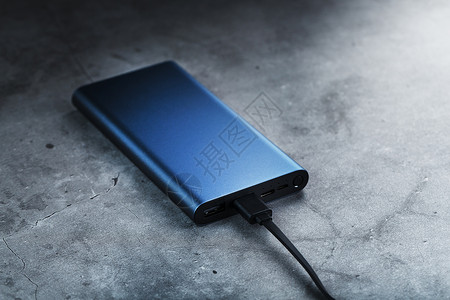 充值返现与USB Cord的蓝色便携式外部电池电力银行端口桌子电缆笔记本来源累加器充电宝背景电脑活力背景