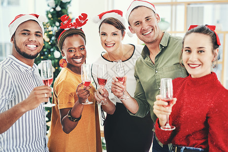 我们祝大家圣诞快乐 一群有创意的商务人士在他们的办公室圣诞派对上喝香槟和庆祝的肖像背景图片