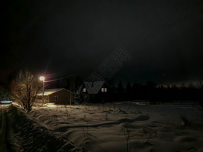 冬天夜晚房子冬季夜晚俄罗斯村庄 一条有雪和光的公路 从房屋窗户上走出来建筑国家旅行小屋降雪森林旅游季节木头夜空背景