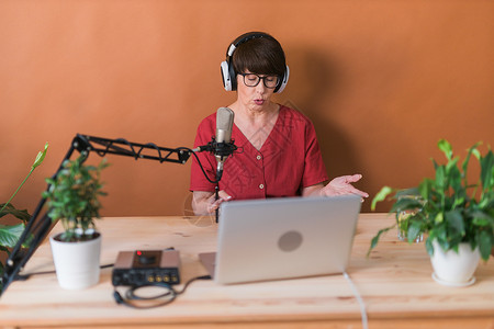 中年女电台主持人为在线节目制作播客录音  广播和 DJ 概念立体声电脑笔记本办公室嗓音播送麦克风打碟机企业家公告人们高清图片素材