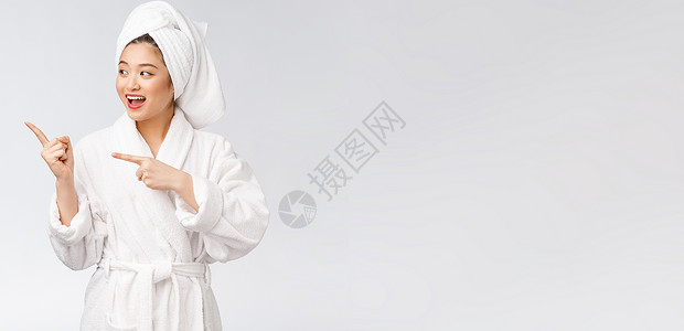 年轻女性的美容肖像显示并指向空空间复制 浴袍中的亚洲美护理手势广告皮肤展示成人成功快乐女孩化妆品背景图片