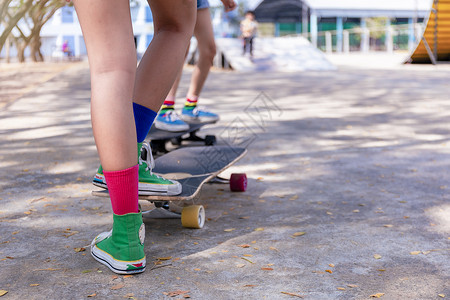 滑板女孩在美丽的早晨 在户外特写亚洲女孩冲浪滑冰或滑板 早上 快乐的小女孩在坡道公园玩冲浪滑冰 特写亚洲女性腿部穿着运动鞋在公园玩冲浪滑背景