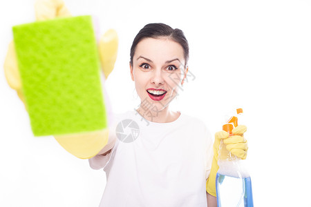 穿着黄色手套的快乐女人 在另一只手上展示了绿海绵 她有清洁用品 白色工作室背景家务高清图片素材