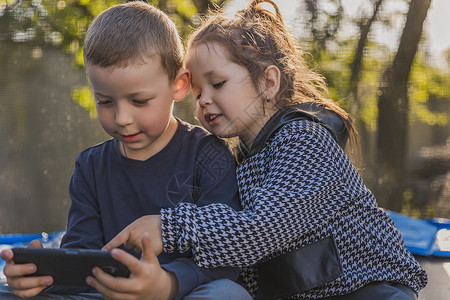 影视娱乐孩子们看着电话看手臂家庭手机手表电讯系统孩子说话娱乐互联网背景