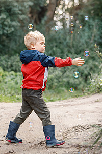 红色泡泡快乐的孩子在户外玩泡泡 有选择地关注  孩子在运动靴子肥皂泡生活闲暇假期幸福气泡肥皂儿子金发女郎背景
