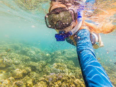 戴着浮潜面具的快乐女人在珊瑚礁海池中与热带鱼一起潜入水下 旅行生活方式 水上运动户外探险 夏季海滩度假游泳课程海洋冒险海底世界女脸高清图片素材