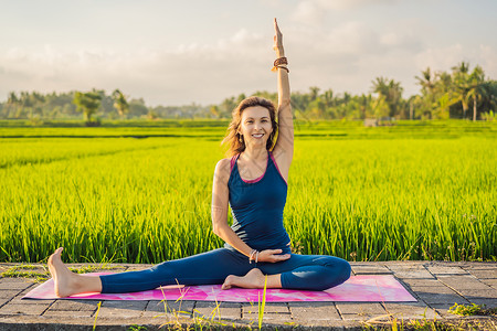 年轻女性在巴厘健康务虚会当天早上在稻田户外做瑜伽灵活性乌布奢华姿势运动花园成人公园冥想健康背景