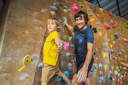 爸爸和儿子在攀岩墙 家庭运动 健康生活方式 幸福家庭乐趣孩子行动婴儿灵活性团队比赛运动装游戏冒险背景图片