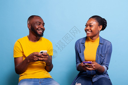 男人和女人手持智能手机 互相笑笑背景图片