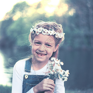 黄色小菊花花环一个小女孩的肖像画 在花圈 菊花和花束微笑阳光照片场地洋甘菊冒充花环草地乐趣孩子背景