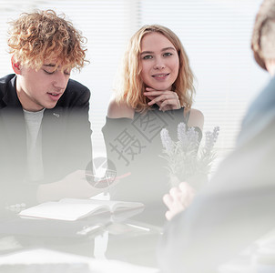 全神贯注地工作 一群年轻的商务人士与同事坐在办公桌前工作和交流职员高清图片素材