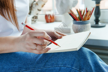 一支铅笔女人手中的铅笔 用一支简单的铅笔在一张纸上画画 创造力和绘画的概念文档女性木头教育学习插图草图日记文书办公室背景