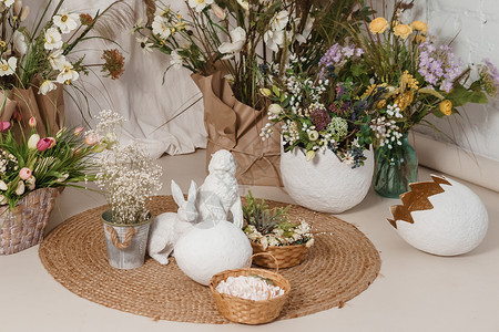 小岛上的兔子室内花卉复活节组成 复活节兔子和一个大蛋壳的小雕像 复活节快乐假期的家居装饰概念塑像雏菊文化花朵创造力花束插花庆典静物风格背景