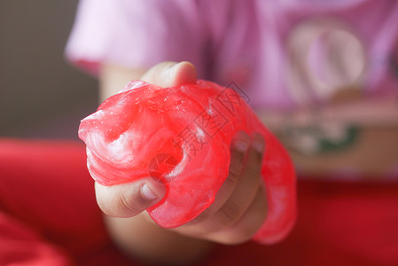 粉色人偶玩具握着粉色粘液的手孩子乐趣想像力爱好科学娱乐享受实验玩具青春期背景