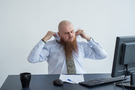 一个穿白衬衫的秃头男子拿着电脑坐在桌子上 因为工作失败而承受压力 精神崩溃 神经衰竭是正常的金融员工技术经理危机焦虑职场办公室商恐慌高清图片素材