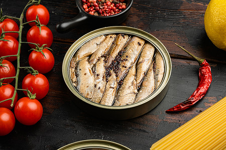 黑鲹和沙丁鱼罐头沙丁鱼 锡罐海鱼 旧黑木桌底背景