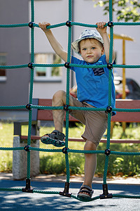 小男孩 操场和攀爬绳塔公园蜘蛛喜悦假期享受蓝色短裤训练快乐安全网高清图片素材