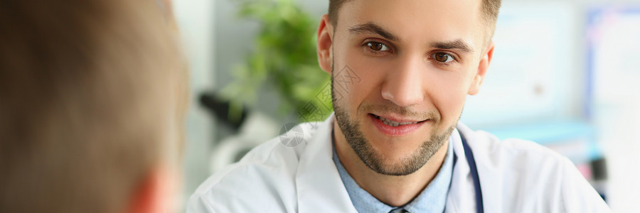 年轻男医生倾听病人的近视面孔疾病情况男人男性专家办公室治疗诊所考试工作流行性高清图片素材