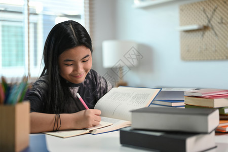 在家里做功课的少女微笑学校青年孩子工作教科书阅读学习孩子们女性家庭女士高清图片素材