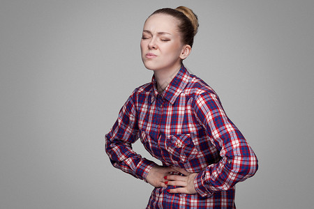 灰色背景的情感金发女孩肠胃便秘胀气腹痛痛苦保健医疗腹泻疼痛卫生图片