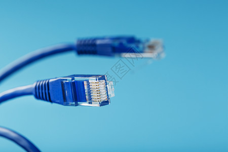 Ethernet 电缆连接器 Patch 绳索线紧贴在蓝色背景上 有自由空间商业技术布线插座电讯绳索局域网服务器路由器宽带速度高清图片素材