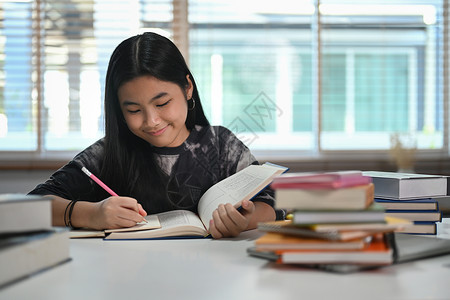 重点写在笔记本上 在客厅做功课的亚洲女孩 教育概念美丽的高清图片素材