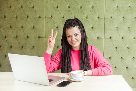 穿粉红色衬衫的情感女性在办公室工作成功工人商务绿色辫子笔记本拉丁女士电脑商业背景图片