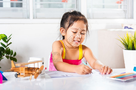 小女孩在涂漆颜色前用纸上画卡通画草图框架孩子们铅笔学生班级幼儿园童年绘画学习手高清图片素材