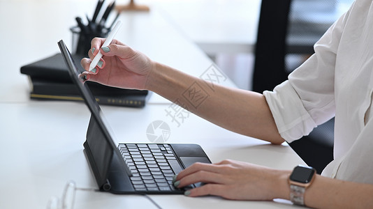 在电脑平板电脑屏幕上指着钢笔的裁剪商业女商务人士药片高清图片素材