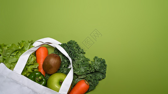 带蔬菜和水果的生态袋 绿色背景顶视图高清图片素材
