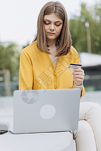 白人女性使用数字移动设备持有信用卡并在线购买 网上购物 将银行卡号键入智能手机的女性手背景图片