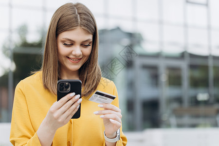女手在智能手机中键入银行卡号 使用数字移动设备持有信用卡并在网上购物的白人女性背景图片