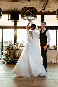 新娘和新郎的第一次婚礼舞裙子套装宴会大厅旋转日落夫妻餐厅马夫舞蹈背景图片