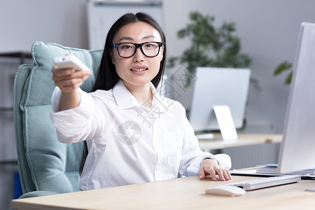 工作场所的热度 一位年轻的亚洲女商务人士坐在办公桌前背景图片