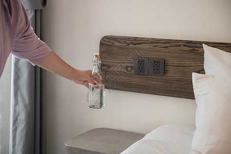 酒店工作人员正在卧室放置饮用水瓶高清图片