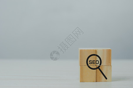 Wooden 立方体 带有放大玻璃图标和缩略语战略SEO搜索引擎优化排名概念广告高清图片素材