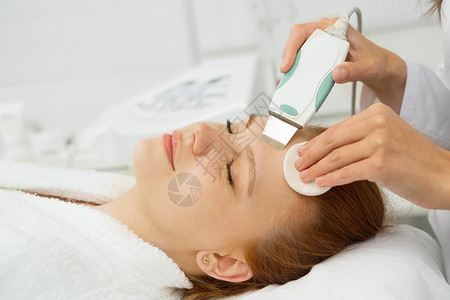 在美容诊所做超声波面部清洗的漂亮女人职业皮肤卫生工作保健程序治疗清洁护理沙龙微晶换肤术高清图片素材