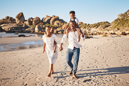 年轻的非洲裔美国父母手牵着手 带着他们的两个孩子 沿着海滩散步的全长肖像 有小女儿和儿子的年轻家庭共度时光 享受假期孩子们女士男父亲高清图片素材