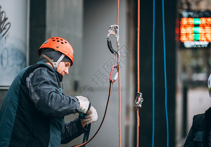 工人登山者准备在高度工作建造细绳风险控制绳索电缆职业齿轮安全工业背景